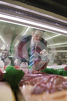 Man Looking At Meat In Supermarket