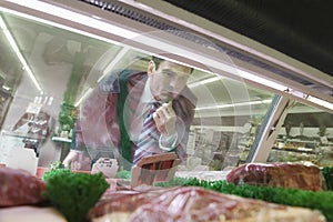 Man Looking At Meat In Supermarket