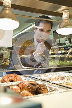 Man Looking At Meat In Supermarket