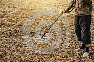 Man is looking for metal objects, a treasure buried in the ground with a metal detector. Sensitive metal detector frame above