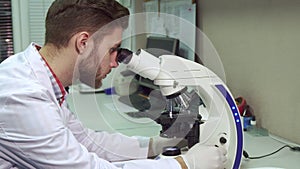 Man looking through the microscope at the laboratory