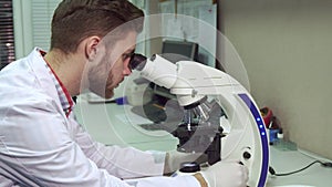 Man looking through the microscope at the laboratory