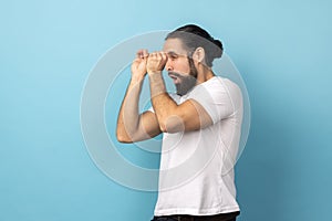 Man looking through monocular gesture and expressing surprise, zooming vision, exploring distance.