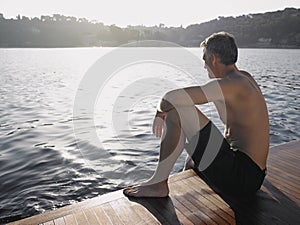 Man Looking At Ocean While Sitting On Yacht's Floorboard