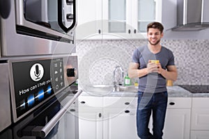 Man Looking At Oven With Voice Recognition Function