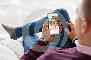 Man looking at photo sharing app on mobile phone