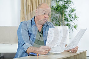 man looking at plans before assembling funiture