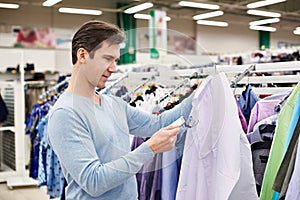 Man looking at price tag of goods