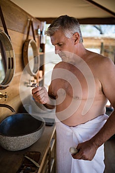 Man looking at razor in cottage