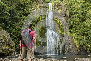 Man looking at scenic waterfall in New Zealand