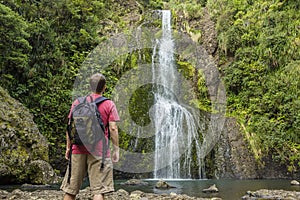 Man looking at scenic waterfall in New Zealand photo