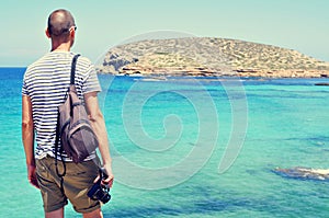 Man looking at the sea and the Illa des Bosc island, in Ibiza, S