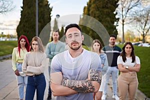 Man looking serious at the camera while standing in front of a group of people.