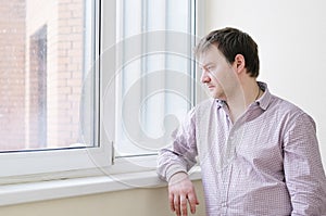 Man looking at snow into the window