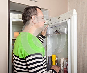Man looking for something in refrigerator