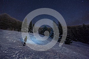 Man is looking on stars in night winter forest, beautiful background, Donovaly, Slovakia