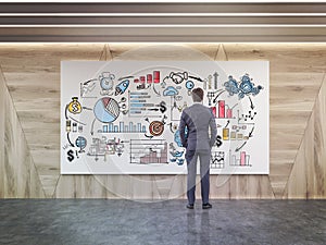 Man looking at startup sketch in wooden walls room