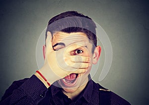 Man looking surprised in disbelief, with hand on face