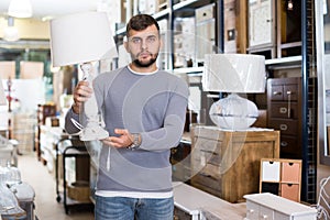 Man looking for table lamp in shop