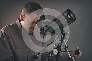 Man looking through telescope