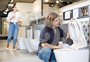 Man looking to buy new toilet in harware store photo