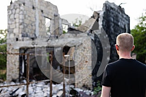 Man looking to his ruined and burnt house by russian troops.