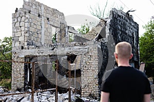 Man looking to his ruined and burnt house by russian troops.