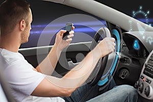 Man looking to smart phone while driving car