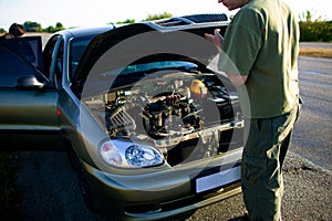 Man Looking Under The Hood Of Breakdown Car van.