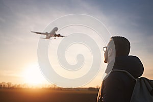 Man looking up to airplane landing at airport