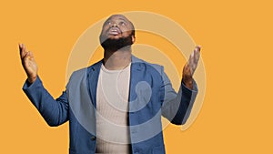 Man looking up to sky hoping for miracle, studio background