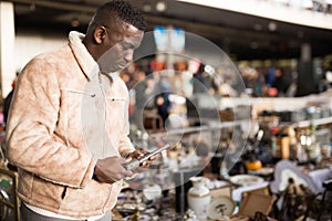 Man looking at used items at a flea market