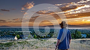 Man looks in awe at a golden sunset over a peaceful city