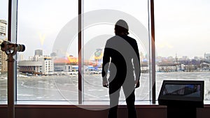 A man looks at a beautiful view of the city and a frozen lake from the observation deck. Media. Rear view of a young man