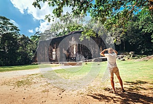 Man looks on Buduruwagala - oldest Buddha statue in Sri Lanka c