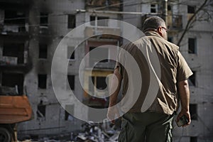 A man looks at a destroyed house that was hit by a shell