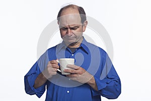 Man looks at empty cup of coffee, horizontal
