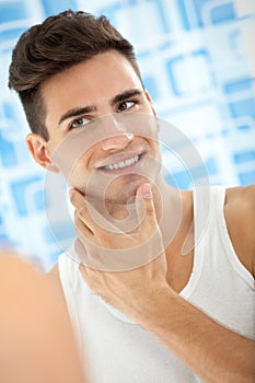 Man looks himself in bathroom mirror