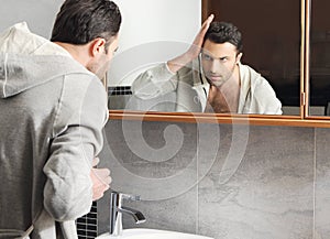 Man looks at himself in the mirror