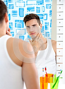 Man looks at himself in mirror