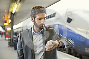 Man looks his watch on the platform station