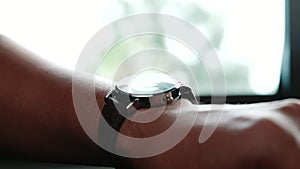 Man looks at his wristwatch. Close-up