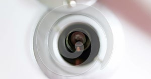 Man looks through a house or hotel peephole of white door with his hand, zoom in and zoom out camera movement, check security