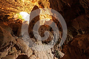 A man looks at the large stalagmite in the limestone cave