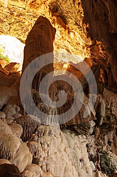 A man looks at the large stalagmite in the limestone cave