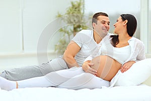 Man looks lovingly at his pregnant