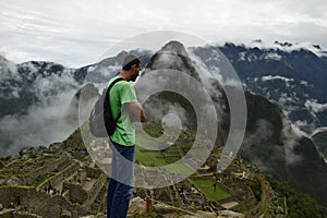 A man looks at the ruins of Machu Pichhu. Peru