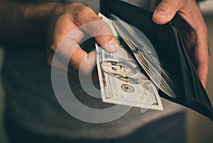 Man looks in the wallet. Cash. Wealthy man counting his money. Close up. photo