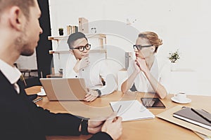 The man looks at woman who is sitting at table.