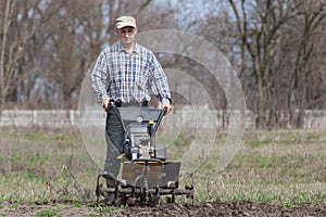 Man loosens the soil cultivator